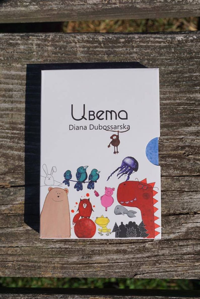May include: A white book with a blue border and the title "Ubema Diana Dubossarska" on the front cover. The cover features colorful illustrations of animals, including a bear, a rabbit, birds, a pig, a dinosaur, a fish, and a frog.