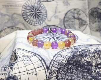 May include: A multi-colored beaded bracelet with pink, purple, and yellow beads. The bracelet has a magnetic clasp.