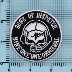 May include: Black and white embroidered patch with the text "Sons of Dispatch Nine One One Original" in a circle around a white skull wearing headphones.