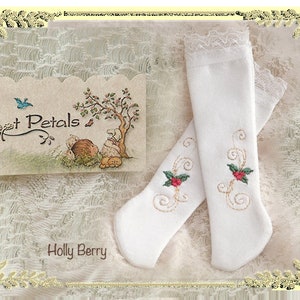 May include: A pair of white knee-high socks with a delicate lace trim and embroidered holly berry designs. The socks are displayed on a white lace background with a card that reads "Foot Petals" and "Holly Berry".