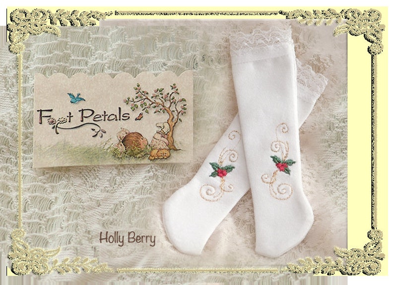 May include: A pair of white knee-high socks with a delicate lace trim and embroidered holly berry designs. The socks are displayed on a white lace background with a card that reads "Foot Petals" and "Holly Berry".