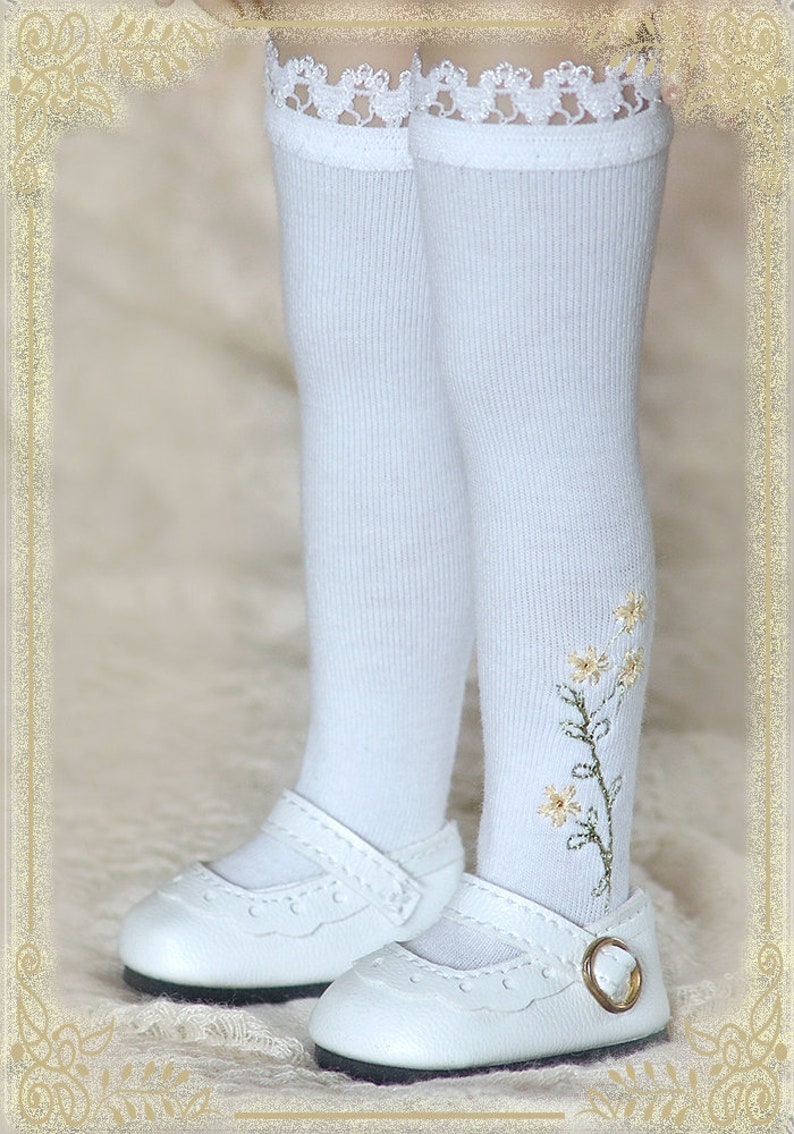 May include: White knee-high socks with a floral embroidery design and white lace trim. The socks are paired with white leather shoes with a buckle.