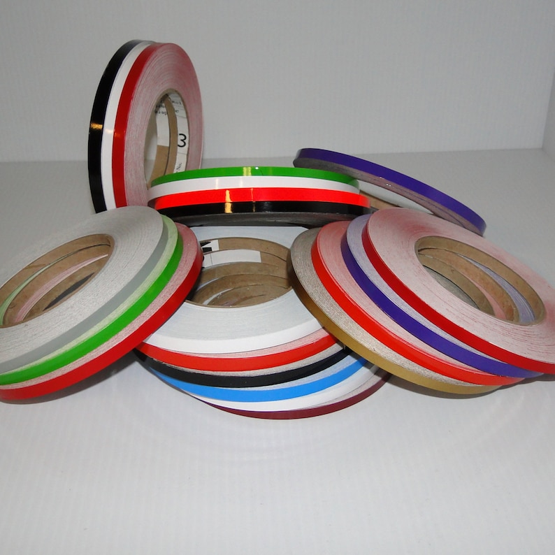 May include: Assortment of colorful vinyl tape rolls, including red, white, green, blue, black, gold, and purple. The tape is 1/4 inch wide and is ideal for crafts, decorating, and adding a pop of color to projects.