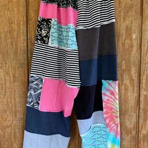May include: Patchwork pants with a variety of patterns, including stripes, animal print, and tie-dye. The pants are made from different fabrics and colors, including black, white, pink, blue, and gray.