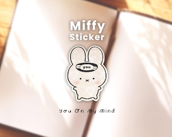 May include: A Miffy sticker with a cream-colored bunny design, featuring a black outline and a small heart pattern. The sticker has the text "Miffy Sticker" at the top and "You On My Mind" at the bottom. The bunny has a small halo with the word "you".