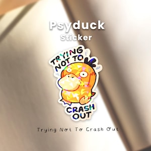 May include: A holographic sticker featuring a yellow Psyduck character with a distressed expression. The text TRYING NOT TO CRASH OUT is printed in black above and below the character. The sticker has a reflective, multi-colored geometric finish.