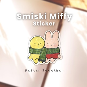 May include: A sticker featuring two cartoon characters: a yellow figure and a pink bunny. They are wearing a green plaid scarf and are hugging. The sticker has the text "Smiski Miffy Sticker" and "Better Together".