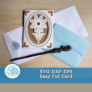 Op de afbeelding: Een witte kaart met een bruine ovale uitsparing met een wit bloemenontwerp. De kaart wordt omringd door twee witte enveloppen en een blauwe envelop. De tekst "SVG-DXF-EPS Easy Cut Card" wordt onder de kaart weergegeven.