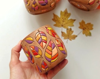 Handmade ceramic mug with colorful leaves