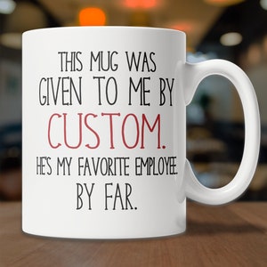May include: White ceramic mug with black text that reads "This mug was given to me by CUSTOM. He's my favorite employee. By far."