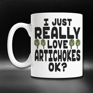 May include: White ceramic mug with a black graphic that says "I just really love artichokes ok?" with three green artichoke illustrations.