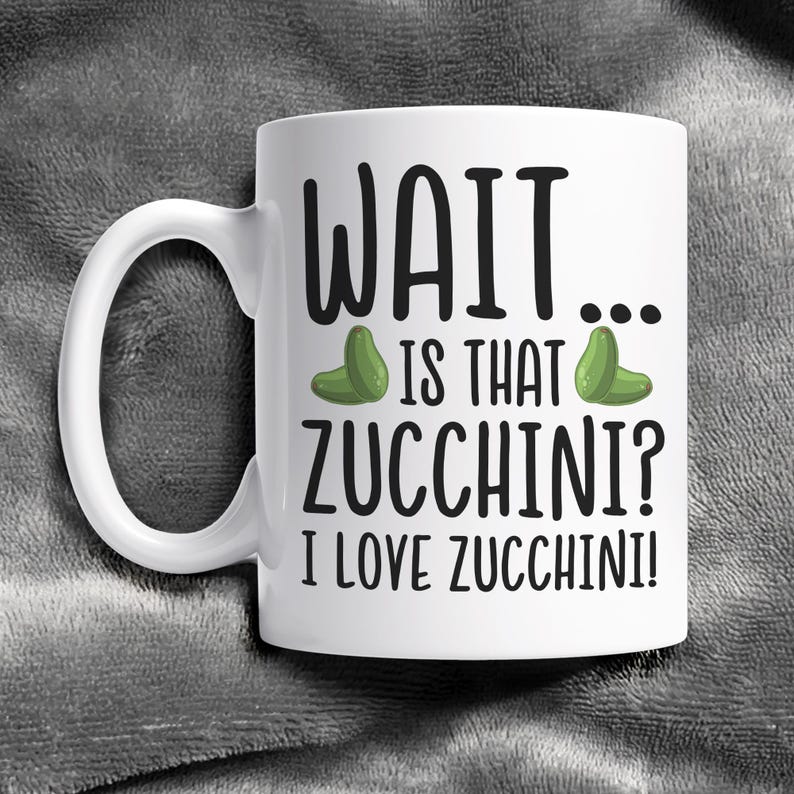 May include: White ceramic coffee mug with a black and green design. The mug says "WAIT... IS THAT ZUCCHINI? I LOVE ZUCCHINI!"