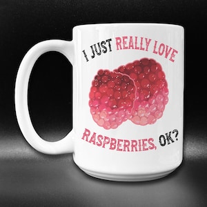 May include: White ceramic mug with a black and red graphic that says "I just really love raspberries, ok?" with two red raspberries on the left side of the text.