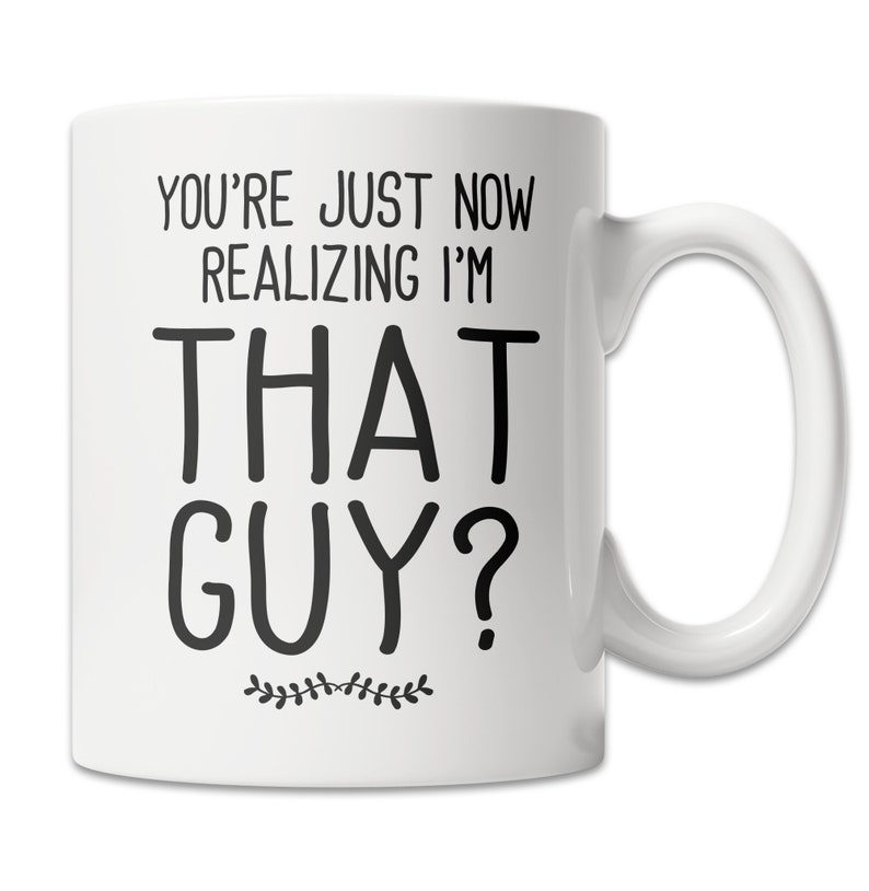 May include: White ceramic coffee mug with black text that reads "You're just now realizing I'm that guy?" with a small floral design at the bottom.