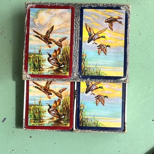 Um conjunto duplo de cartas de baralho dos anos 1920 e 1930, com lindos fundos ilustrados com patos, completo.