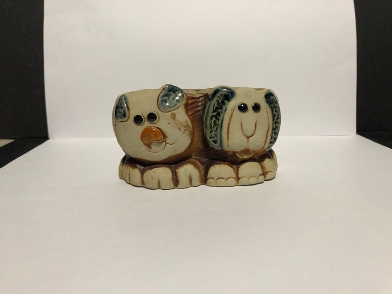 May include: Ceramic planter shaped like two dogs, one brown and one gray, with blue eyes and brown noses.