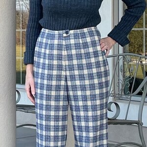 May include: Blue and white plaid wide-leg pants with a dark blue turtleneck sweater.