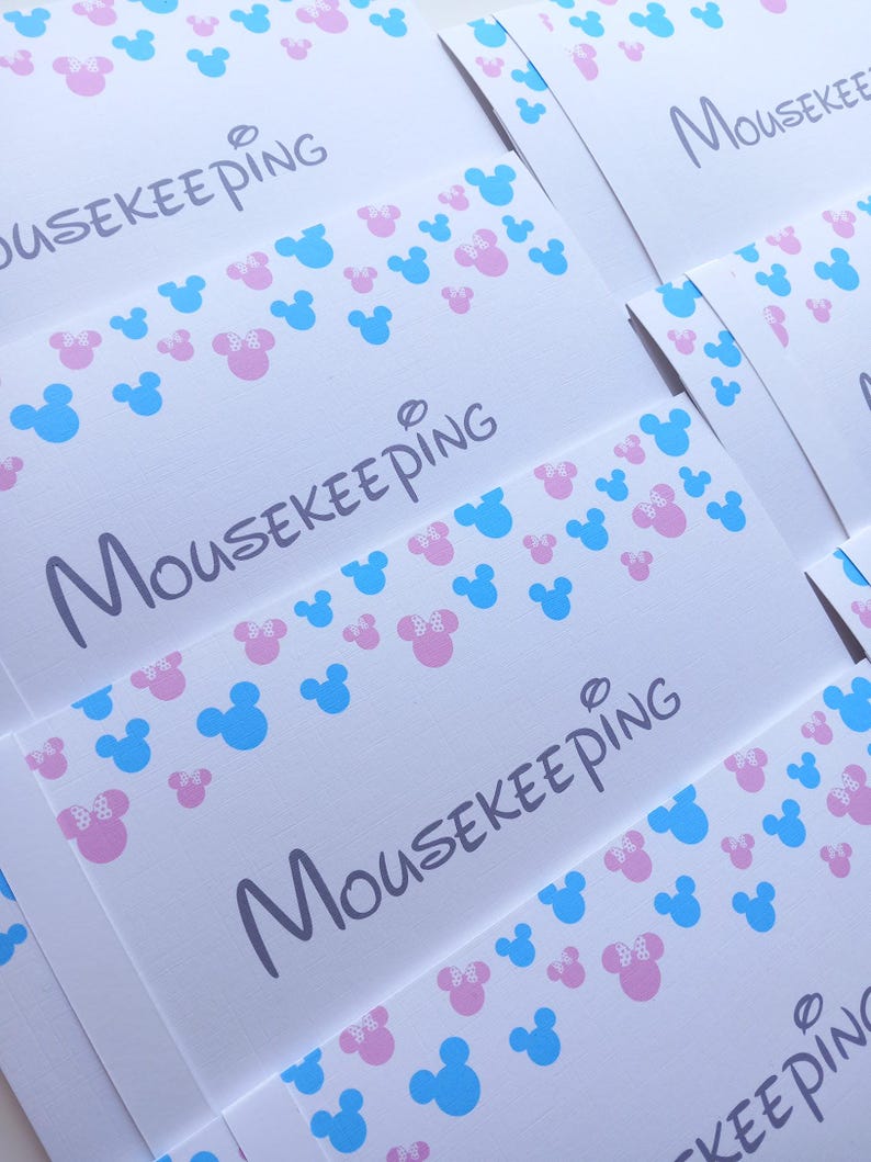 May include: A collection of white rectangular envelopes featuring the word MOUSEKEEPING printed in a dark gray script font. The envelopes are decorated with a repeating pattern of small light blue and pink mouse head silhouettes.