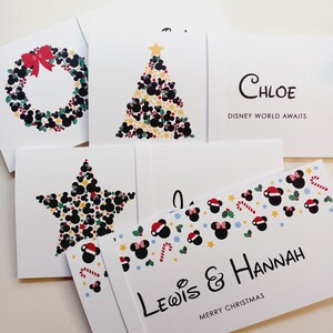 May include: A collection of white greeting cards featuring festive designs with black mouse-ear silhouettes, red bows, holly, and stars. One card displays the text Chloe Disney World Awaits, and another shows Lewis & Hannah Merry Christmas.