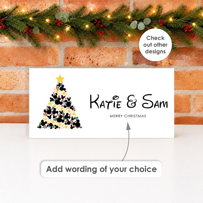 May include: A rectangular white sign featuring a Christmas tree graphic composed of black mouse-ear silhouettes, green leaves, red berries, and yellow stars, topped with a yellow star. The text reads Katie & Sam, MERRY CHRISTMAS, and Add wording of your choice.