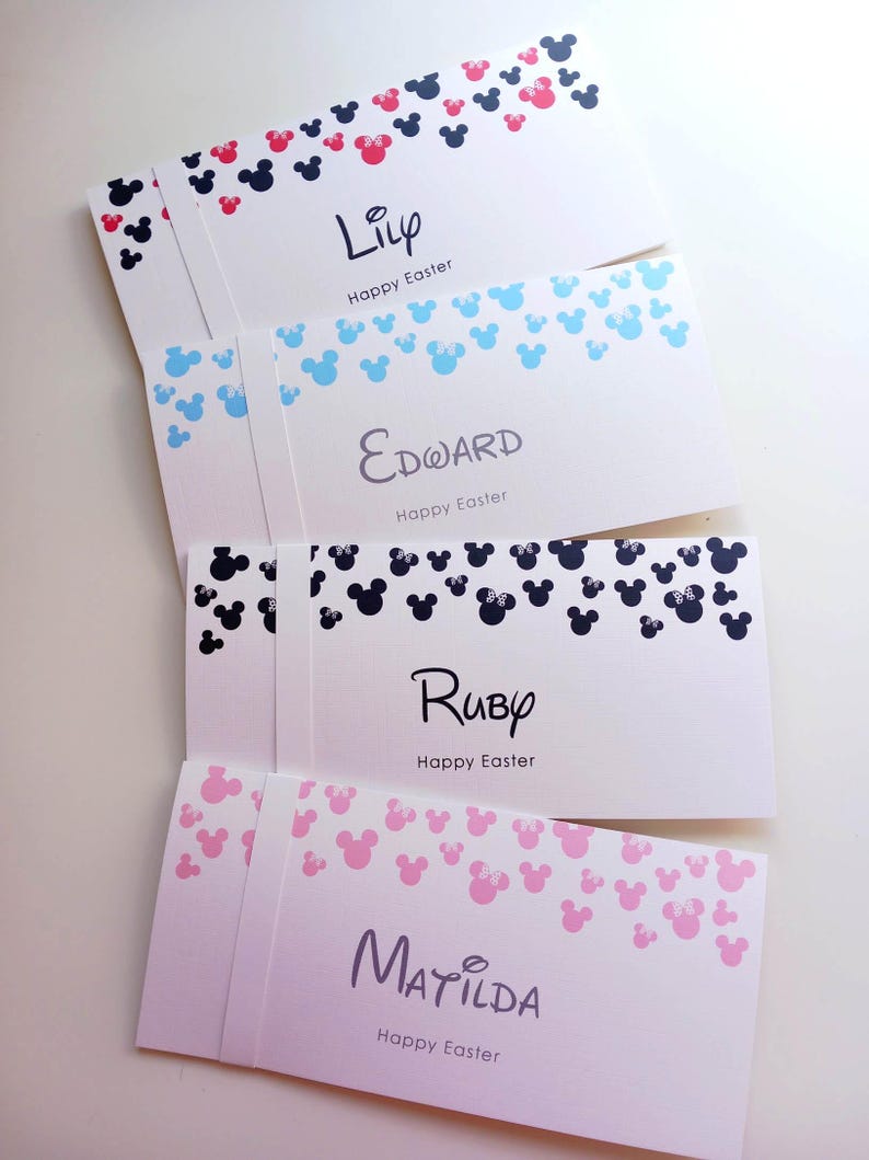 May include: Four white rectangular envelopes featuring a top border of scattered mouse-ear silhouettes. The envelopes are personalized with the names Lily, Edward, Ruby, and Matilda, each followed by the printed text Happy Easter.