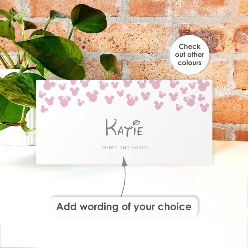 May include: A rectangular white card featuring a pattern of light pink Mickey Mouse silhouettes along the top edge. The center displays the name Katie in dark gray text, with the phrase Disneyland Awaits below it and an arrow pointing to the text.