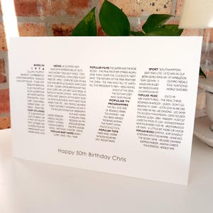 K&ouml;nnte beinhalten: Eine wei&szlig;e Karte mit schwarzem Text, die einen 50. Geburtstag feiert. Die Karte listet Ereignisse aus dem Jahr 1976 auf, darunter Nachrichten, beliebte Filme, Fernsehsendungen, Musik und Sport. Der Text lautet "Happy 50th Birthday Chris."