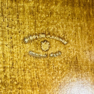 May include: A close-up of a wooden surface with a circular stamp that reads "Original Florence Original Wood".