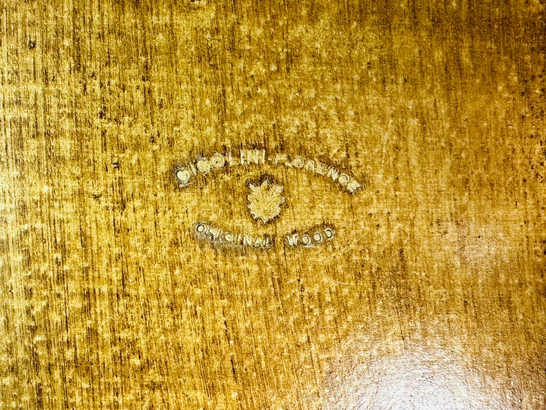 May include: A close-up of a wooden surface with a circular stamp that reads "Original Florence Original Wood".