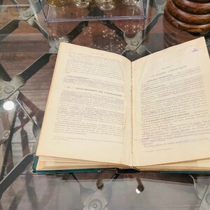 May include: An open book with the title "Les Glandes Lymphatiques" on the right page and "D&eacute;veloppement des Lymphatiques" on the left page. The book is open to a chapter on the lymphatic system.