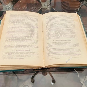 May include: An open book with yellowed pages and a green cover. The book is titled "La Choroide Celiatre" and "L'Iris Choroide" with text in French. The book is open to a page with the text "La Choroide Celiatre" and "L'Iris Choroide" highlighted in blue.
