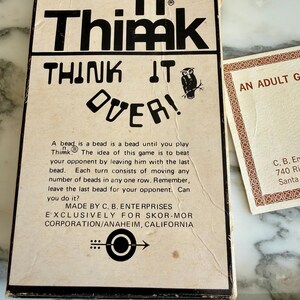 K&ouml;nnte beinhalten: Vintage "n Thimk" Brettspielbox mit fetter schwarzer Schrift und einer Eulenillustration. Auf der Box steht "THINK IT OVER!" und enth&auml;lt Spielanweisungen. Eine Karte mit dekorativen R&auml;ndern ist ebenfalls sichtbar.