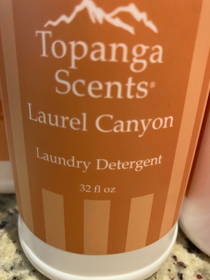 May include: A 32 fl oz bottle of Topanga Scents Laundry Detergent in Laurel Canyon scent. The bottle is orange with white stripes and white text.