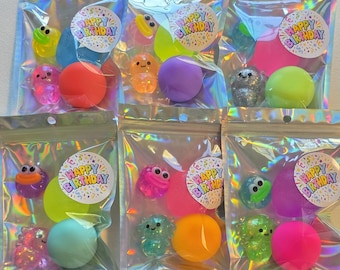 May include: Six holographic pouches containing assorted small toys, including colorful squishy balls and miniature animal figures. Each pouch features a circular sticker with confetti patterns and the text Happy Birthday printed in colorful letters.