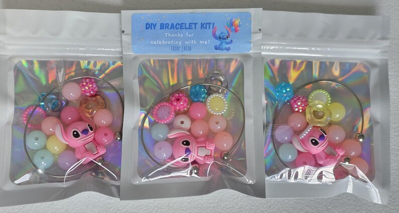 May include: DIY bracelet kits in clear plastic bags. Each kit contains colourful beads, a pink character charm, and a silver-tone bracelet base. The kits are labelled with the text "DIY BRACELET KIT!" and "Thanks for celebrating with me!"