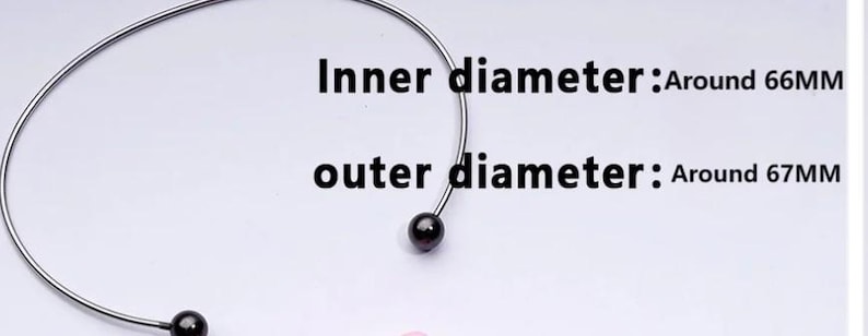 May include: A silver choker necklace with a black bead at each end. The inner diameter is around 6.6 cm, and the outer diameter is around 6.7 cm. The necklace is shown against a white backdrop.