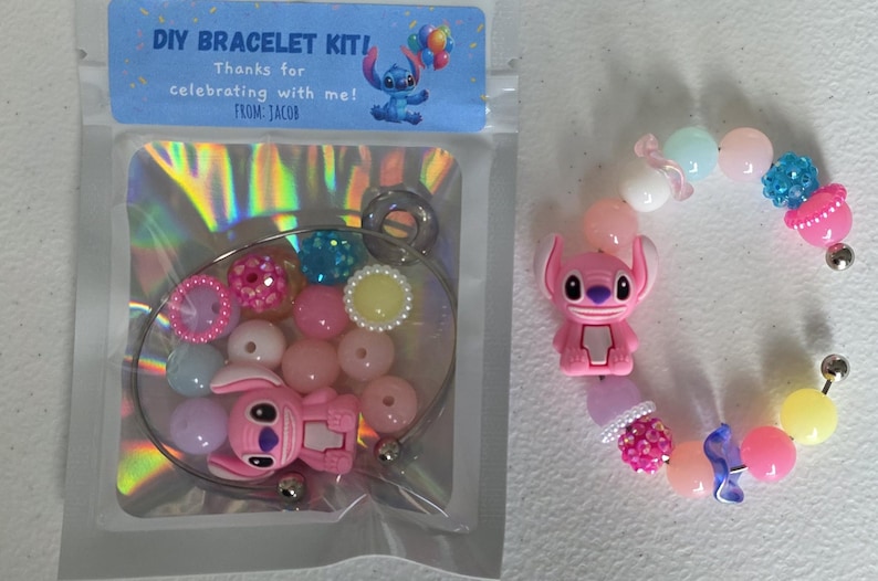 May include: A DIY bracelet kit with a blue label reading "DIY BRACELET KIT! Thanks for celebrating with me! From Jacob." The kit contains a bracelet wire, pink, blue, and yellow beads, and a pink character charm. A finished bracelet is also shown.