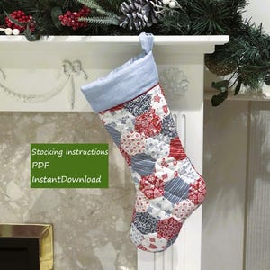 Pode incluir: Uma meia de Natal acolchoada com um design de retalhos em vermelho, branco e azul. A meia tem uma punho azul claro e uma alça para pendurar. O texto "Stocking Instructions PDF InstantDownload" é visível.