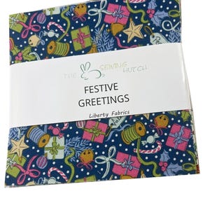 May include: Fabric squares with a Christmas-themed design. The navy blue fabric is patterned with gifts, bells, stars, and candy canes. The text "Festive Greetings" is printed on a white label. The Sewing Hutch and Liberty Fabrics are also printed.