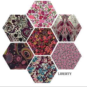May include: A hexagonal arrangement of fabric swatches showcasing a variety of floral and geometric patterns in shades of pink, purple, and brown. The text "LIBERTY" is printed below the swatches.