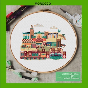 May include: Cross stitch pattern PDF for a colourful illustration of a Moroccan cityscape. The pattern includes buildings, camels, and palm trees. The PDF is for instant download.