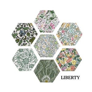 May include: A collection of six hexagonal fabric swatches featuring floral and botanical patterns in shades of green, blue, pink, and yellow. The swatches are arranged in a honeycomb pattern and the word "LIBERTY" is printed below the swatches.