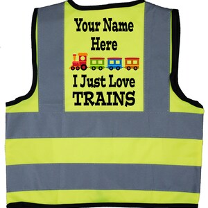 May include: A yellow and grey safety vest with reflective stripes. The vest has a patch on the back that says "Your Name Here" and features a cartoon train with the text "I Just Love TRAINS".