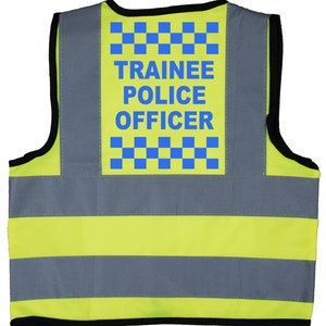 May include: Yellow and grey safety vest with a blue patch that says "TRAINEE POLICE OFFICER" and a chequered pattern.