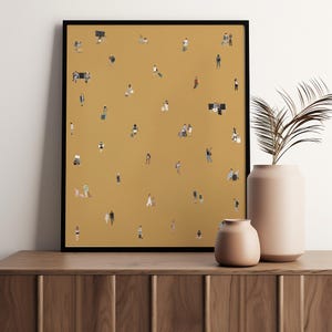 May include: A framed art print featuring a mustard-colored background with numerous tiny figures, suggesting a crowd of people. The figures are dressed in various outfits, some with luggage, and are scattered across the surface. The artwork is displayed on a wooden cabinet with two peach-colored vases.