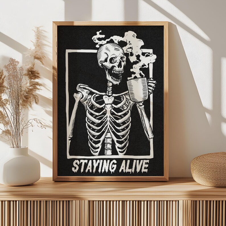 May include: Black and white illustration of a skeleton holding a steaming mug with the text "STAYING ALIVE".