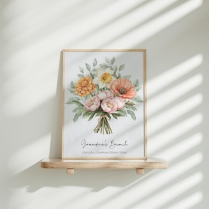 May include: A framed print with a watercolor illustration of a bouquet of flowers in shades of pink, orange, and yellow. The flowers are arranged in a vase and the print has the text "Grandma's Bunch" and the names "Chelsea, Hannah, Sean, Gina".