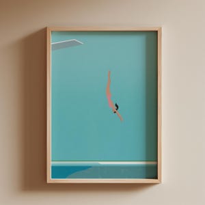 以下が含まれることがあります： プールに飛び込む人のミニマリストイラストが描かれた、額入りのアートプリント。ダイバーはピンクの水着を着ており、ターコイズブルーの背景が特徴です。白い飛び込み台が左上にあります。フレームは明るい色の木材で作られています。