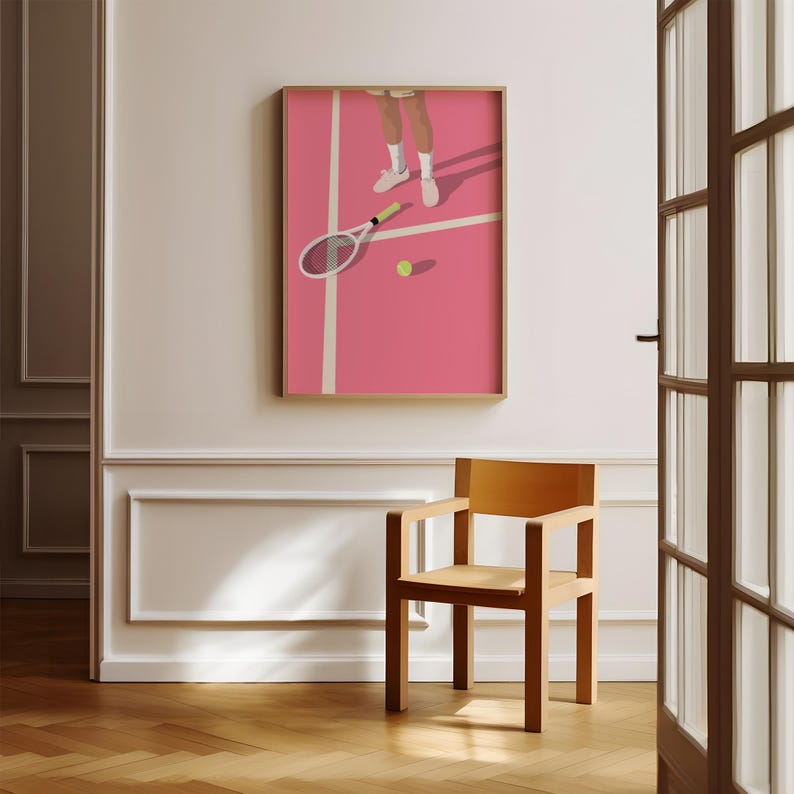 May include: A framed illustration of a tennis player on a pink court. The player is wearing white shoes and shorts. A tennis racket and ball are on the court.