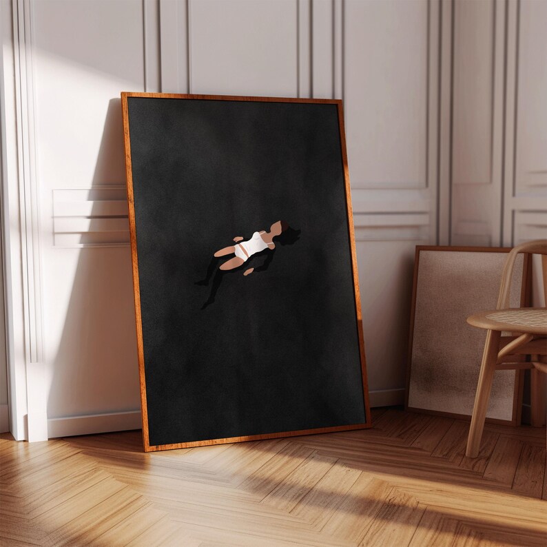 May include: A rectangular wall art print in a thin wooden frame featuring a dark charcoal background with a stylized illustration of a person in a white top and shorts floating in the center. The artwork is displayed in a vertical orientation.